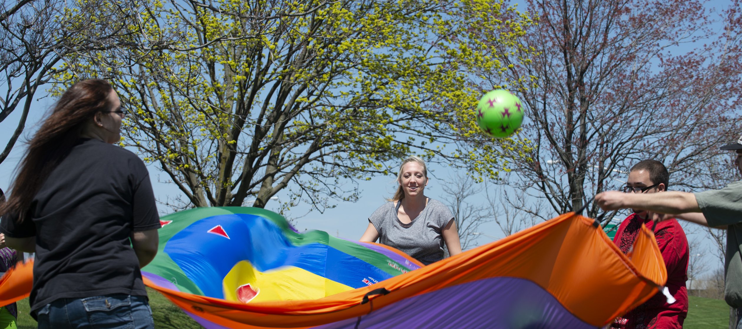 Occupational Therapy students at work with parachute and ball.