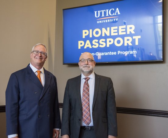 President Todd Pfannestiel and VP of Enrollment Management Eric Sykes stand in front of monitors announcing Pioneer Passport.